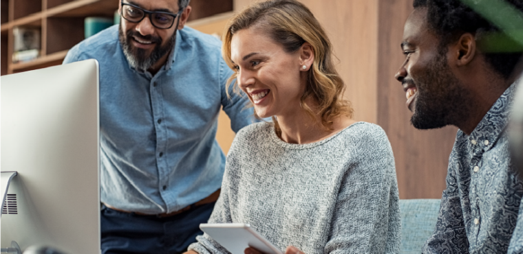 Three people looking at a computer smiling.