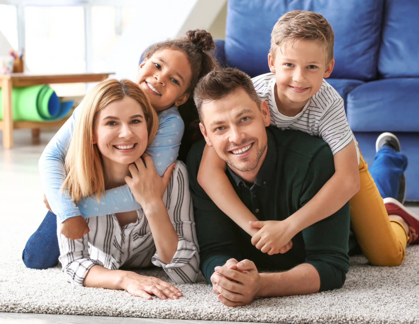 Happy couple with little adopted children at home
