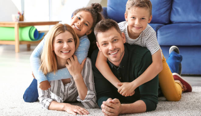 Happy couple with little adopted children at home