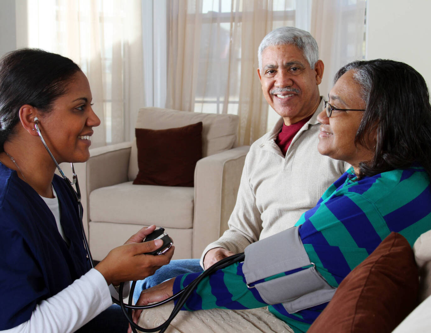 Older couple receiving care at home from a nurse