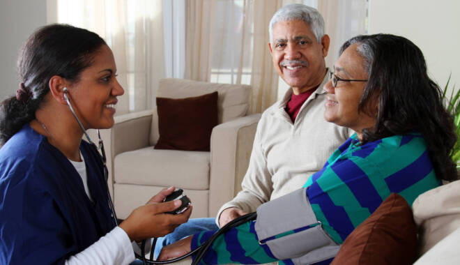 Older couple receiving care at home from a nurse