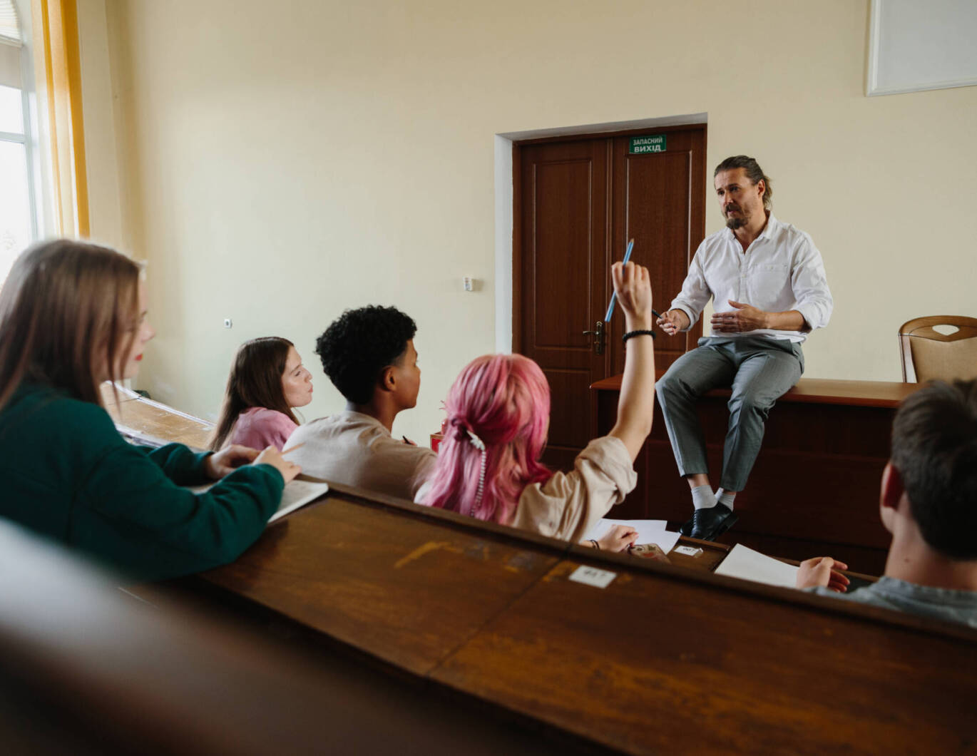 Educator talking to young adults in class