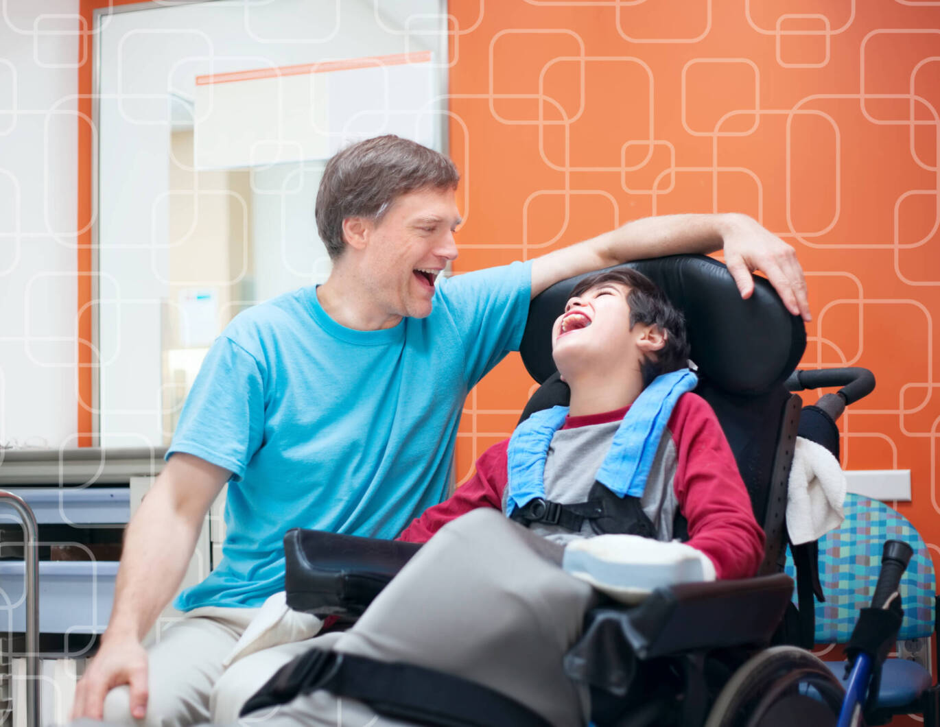 Man and boy in wheelchair laughing together