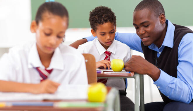 Child being helped by teacher