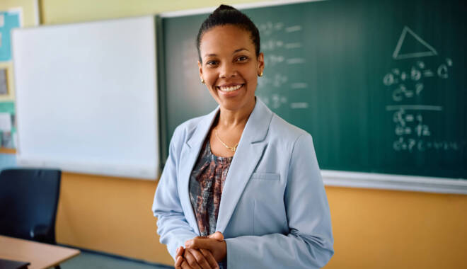 teacher standing in front of black board